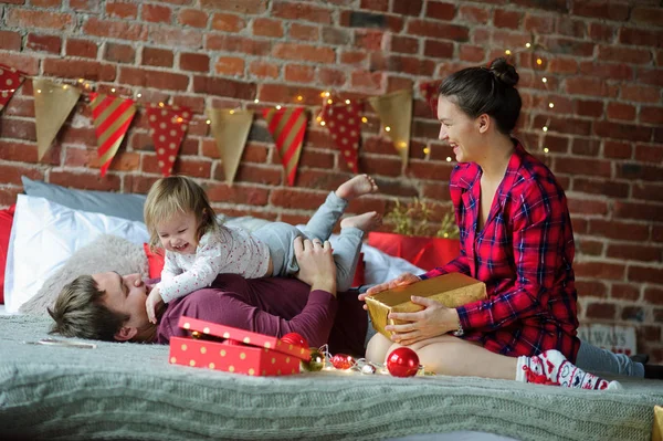 Junge Familie gratuliert frohgemut zu Weihnachten. — Stockfoto