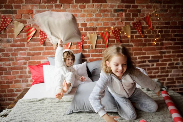 Deux enfants en pyjama doux ont arrangé le combat par des oreillers . — Photo