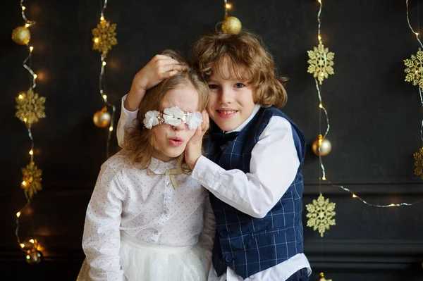 Двое празднично одетых детей сфотографированы на рождественскую открытку . Стоковая Картинка