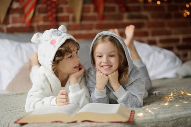 İki çocuk, kardeşi ve kız kardeşi, okumak Noel hikayeleri.