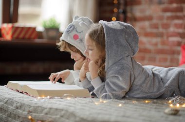 İki çocuk, kardeşi ve kız kardeşi, okumak Noel hikayeleri.