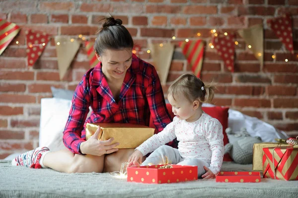 Ung kvinna och hennes lilla dotter med glädje titt på gåvor. — Stockfoto