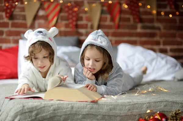 Les enfants lisent un grand livre avec des contes de Noël . — Photo