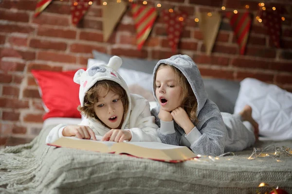 I bambini leggono un grande libro con racconti di Natale . — Foto Stock