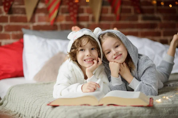 Двоє дітей, брат і сестра, читати Різдво казки. — стокове фото