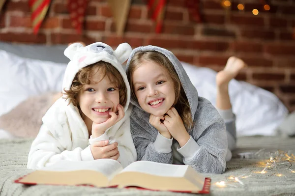 Dvě děti, bratr a sestra, čtení vánočních příběhů. — Stock fotografie