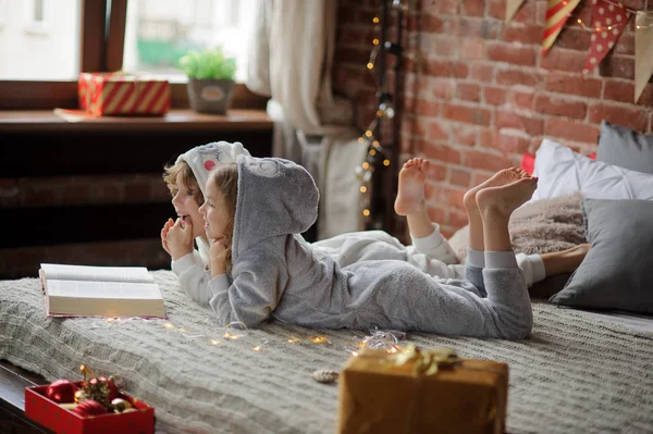 De kinderen lezen een groot boek met kerst-verhalen. — Stockfoto