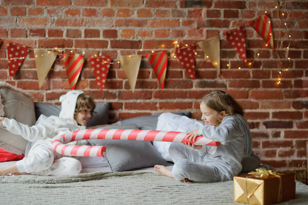 Two children have put up cheerful fight on a big bed.