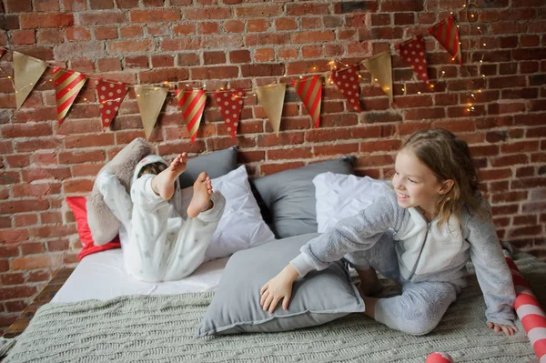 Twee kinderen in pyjama van zachte hebben gerangschikt kussens strijd. — Stockfoto