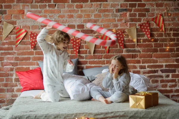 Två barn har lagt upp glada kampen på en stor säng. — Stockfoto