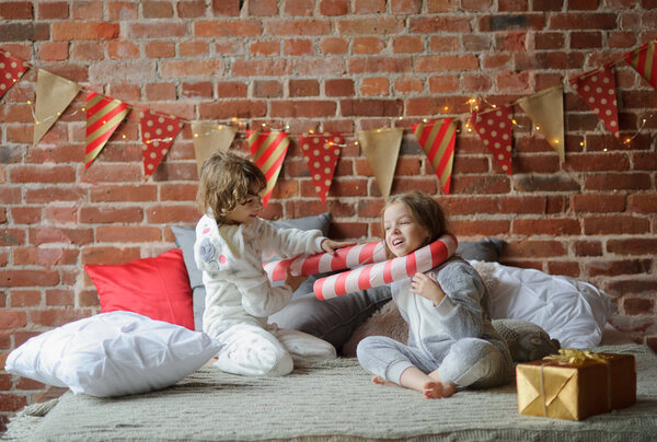 Two children have put up cheerful fight on a big bed.