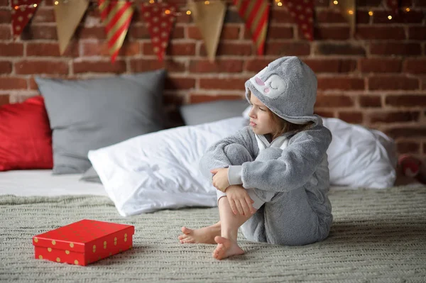 Little girl is disappointed with a gift. — Stock Photo, Image