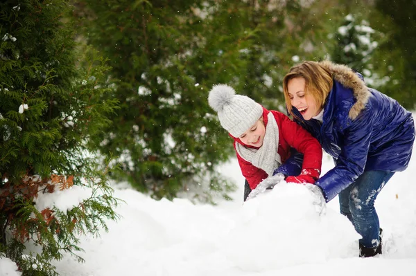 어머니 딸과 함께 공원에서 눈사람을 구축. — 스톡 사진