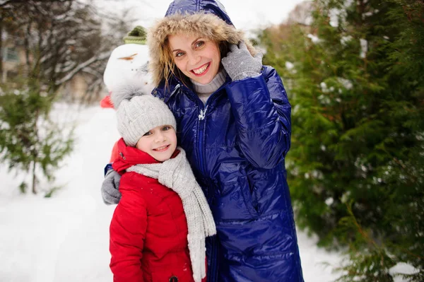 Mãe com filha construíram um boneco de neve e se alegrar . — Fotografia de Stock