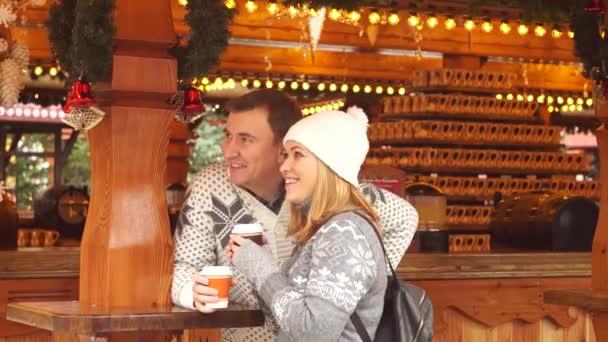 Eva do Natal. Bonito jovem casal tem um bom tempo no bazar de Natal . — Vídeo de Stock