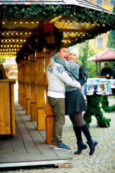 Linda pareja joven tiene buen tiempo en el bazar de Navidad . — Foto de Stock