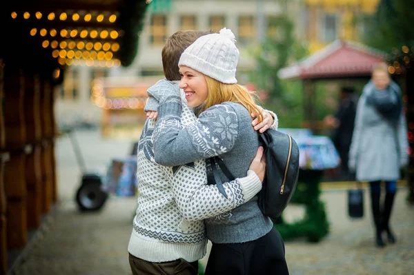 Cute young couple has good time at the Christmas bazaar. — Stock Photo, Image