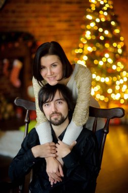 Genç kadın bir sandalyede oturan adam kucaklayan.