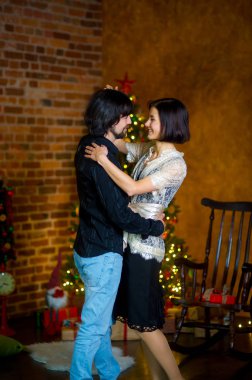 Noel ağacı yakınındaki güzel genç çift dansları.