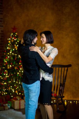 Noel ağacı yakınındaki güzel genç çift dansları.