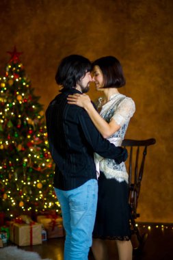 Noel ağacı yakınındaki güzel genç çift dansları.