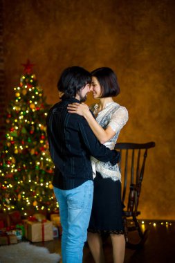 Noel ağacı yakınındaki güzel genç çift dansları.