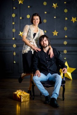 Genç kadın bir sandalyede oturan adam kucaklayan.