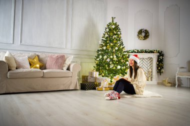 Noel Baba'nın şapkalı kız ortada Noel tarafından dekore edilmiş oda oturuyor..