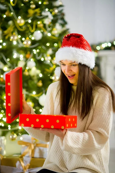 Милая девушка брюнетка открывает коробку с рождественским подарком . — стоковое фото
