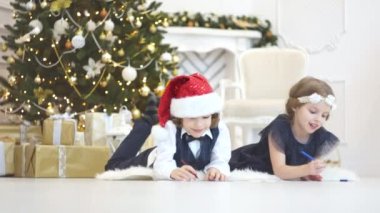 Çocukların Noel Baba'ya mektup yazmak. Çocuklar için neşeli.