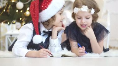 Çocukların Noel Baba'ya mektup yazmak. Çocuklar için neşeli.