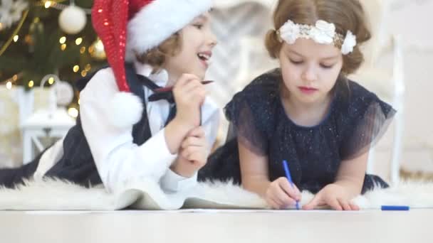 Los niños escriben cartas a Santa Claus. A los niños es alegre . — Vídeo de stock