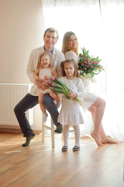 Maravillosa familia joven se encuentra en una silla . — Foto de Stock