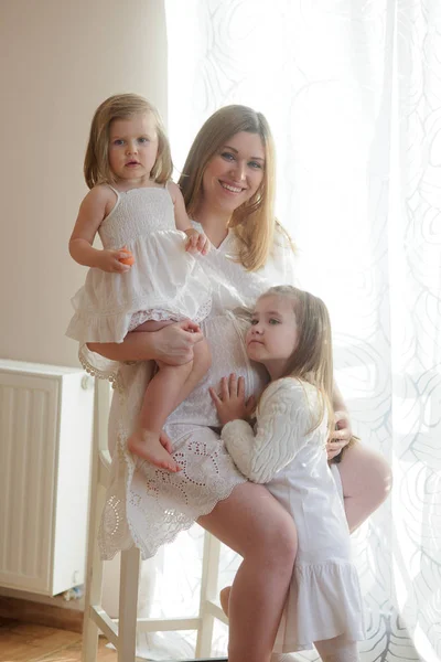 Belle femme enceinte avec deux filles . — Photo