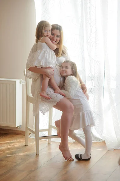 Krásná těhotná žena s dvěma dcerami. — Stock fotografie