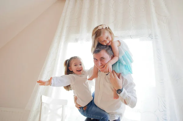 Jonge man besteedt vrolijk tijd met de kleine dochters. — Stockfoto