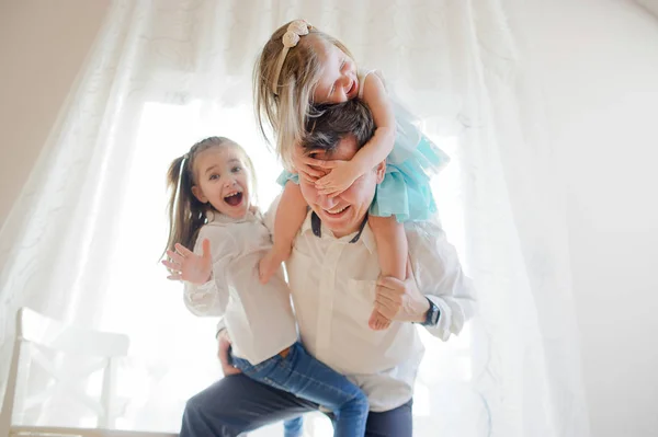 Young father cheerfully spends time with the little daughters. — Stock Photo, Image