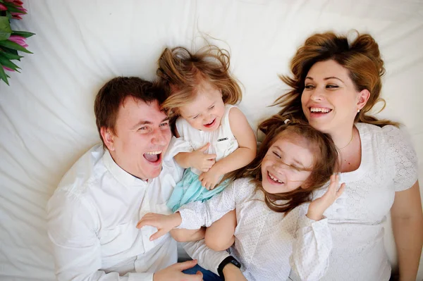 Gran familia unida de cuatro personas pasa alegremente el tiempo para las camas — Foto de Stock