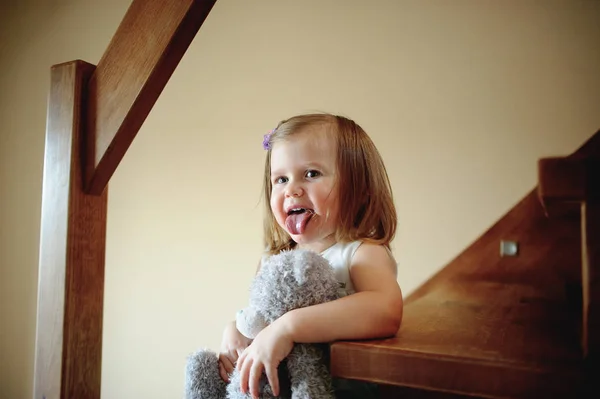 Charming little girl shows tongue. — Stock Photo, Image