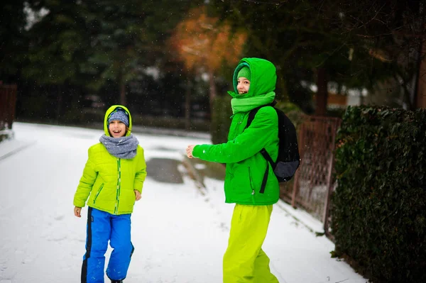 Two boys cheerfully play on the street in winter day. — Stock Photo, Image