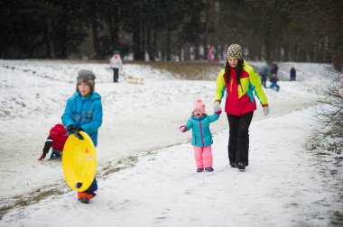 Genç anne küçük kızı kış park getirdi.