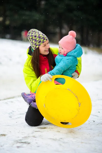 Mother with little daughter have come to ride the sledge into winter park. — Stock Photo, Image