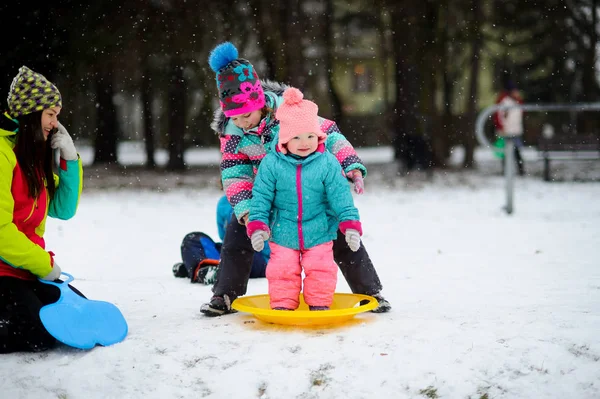 Kış günü yolda iki küçük kızı annesiyle.