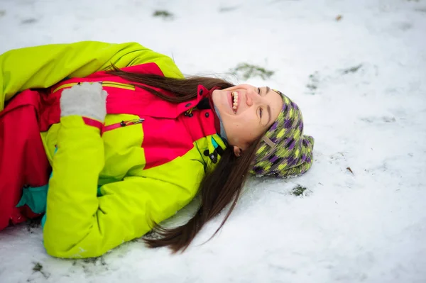 Die charmante junge Frau liegt auf Schnee. — Stockfoto