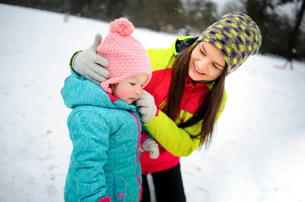 A jovem com a pequena filha no parque de inverno . — Fotografia de Stock