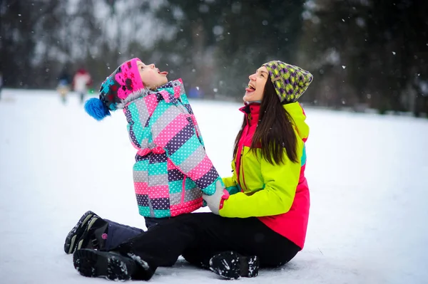 젊은 여자와 밝은 스키 정장에서 여자 눈에 수용 하는 데 앉아. — 스톡 사진