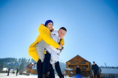 Genç adam kız arkadaşı onun omuzlarında holding