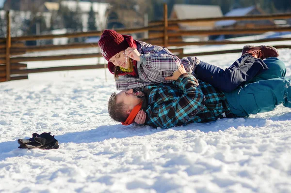 Junges Paar zappelt fröhlich im Schnee — Stockfoto