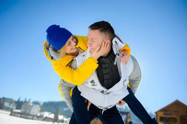 Joven sosteniendo a su novia sobre sus hombros — Foto de Stock