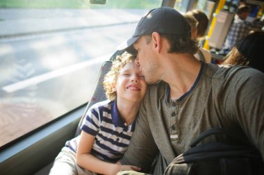 Genç adam oğlu ile birlikte otobüsle gider.